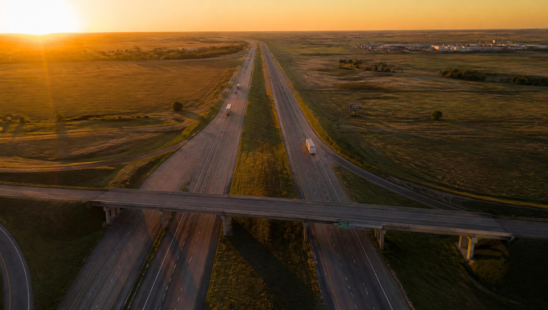 American interstate highway at sunrise with semi trucks
